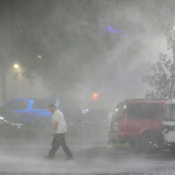 FILE - Max Watts, of Buford, Ga., walks in the parking lot to check on a trailer parked outside the hotel where he is riding out Hurricane Milton with coworkers, Wednesday, Oct. 9, 2024, in Tampa, Fla. Watts, who works for a towing company, was deployed with colleagues to Florida to aid in the aftermath of the storm. (AP Photo/Julio Cortez, File)