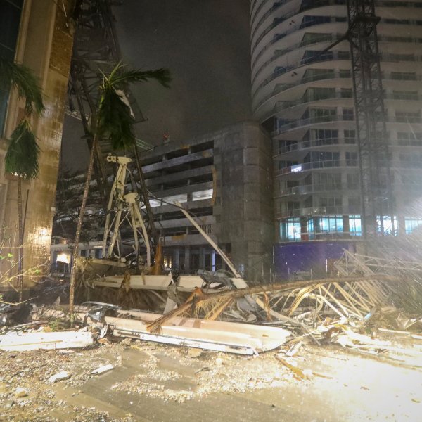 Debris covers the ground near a crane that fell onto a building along 1st Avenue South in St. Petersburg, Fla., as Hurricane Milton's strong winds tore through the area Thursday, Oct. 10, 2024. (Chris Urso/Tampa Bay Times via AP)