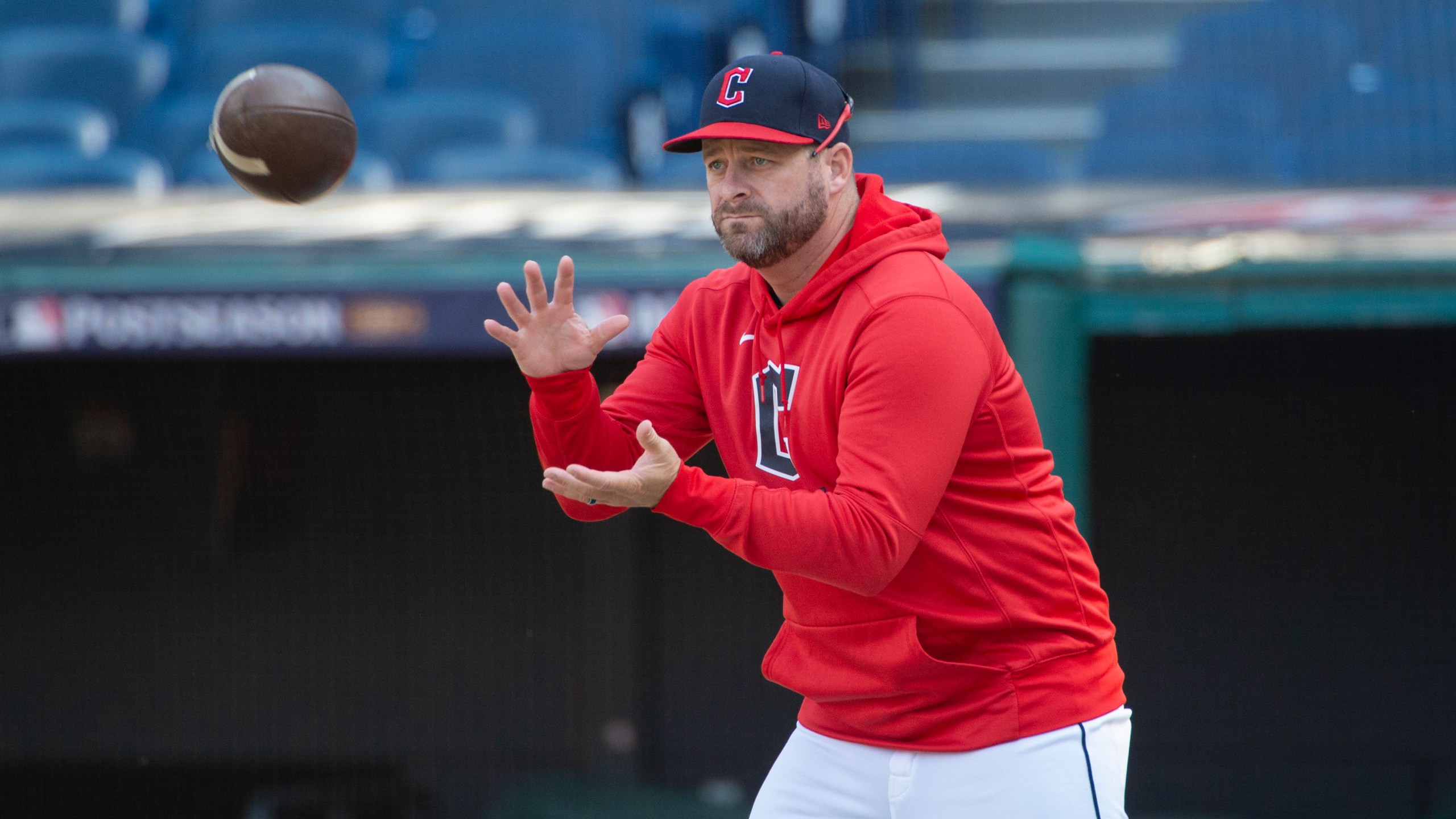 Cleveland Guardians manager Stephen Vogt catches a football during a baseball workout in Cleveland, Friday, Oct. 11, 2024, in preparation for Saturday's Game 5 of the American League Division Series against the Detroit Tigers.(AP Photo/Phil Long)