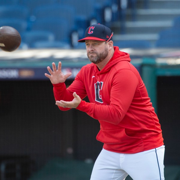 Cleveland Guardians manager Stephen Vogt catches a football during a baseball workout in Cleveland, Friday, Oct. 11, 2024, in preparation for Saturday's Game 5 of the American League Division Series against the Detroit Tigers.(AP Photo/Phil Long)