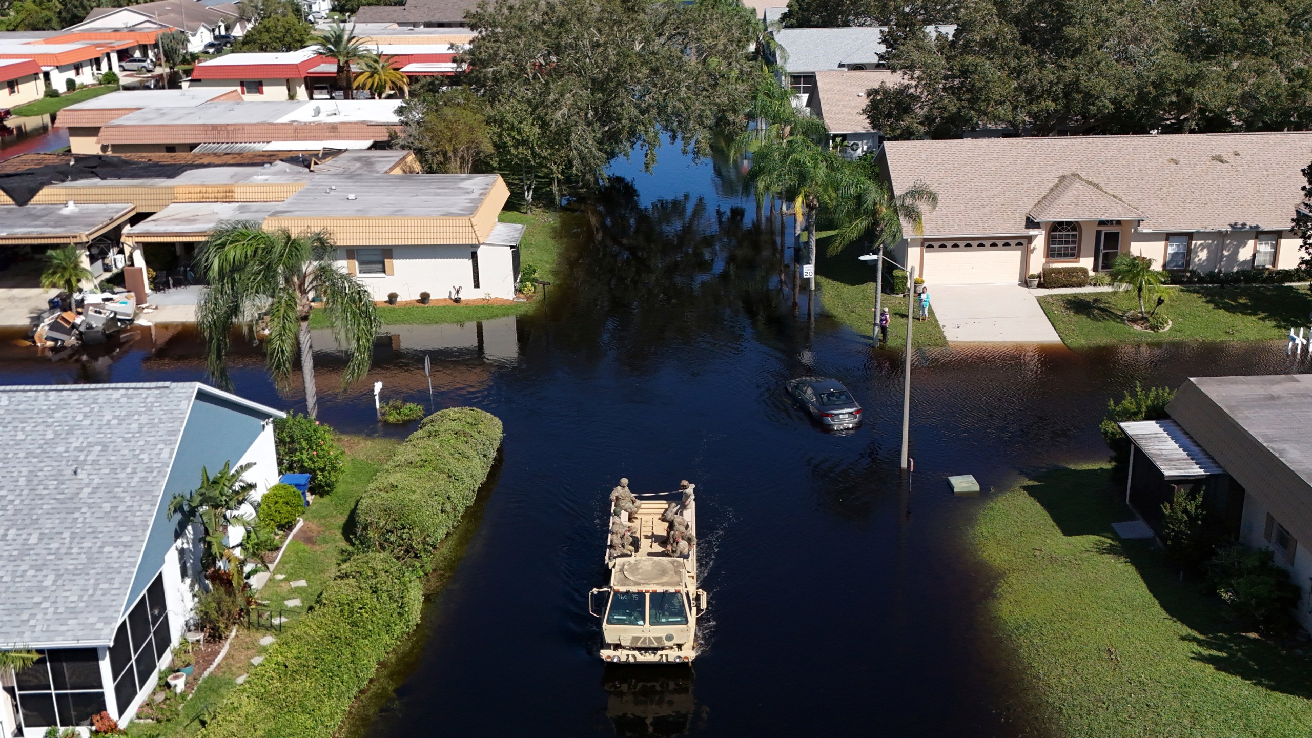 A truck from the Florida National Guard goes out to help residents trapped in their homes as waters rise after Hurricane Milton caused the Anclote River to flood, Friday, Oct. 12, 2024, in New Port Richey, Fla. (AP Photo/Mike Carlson)