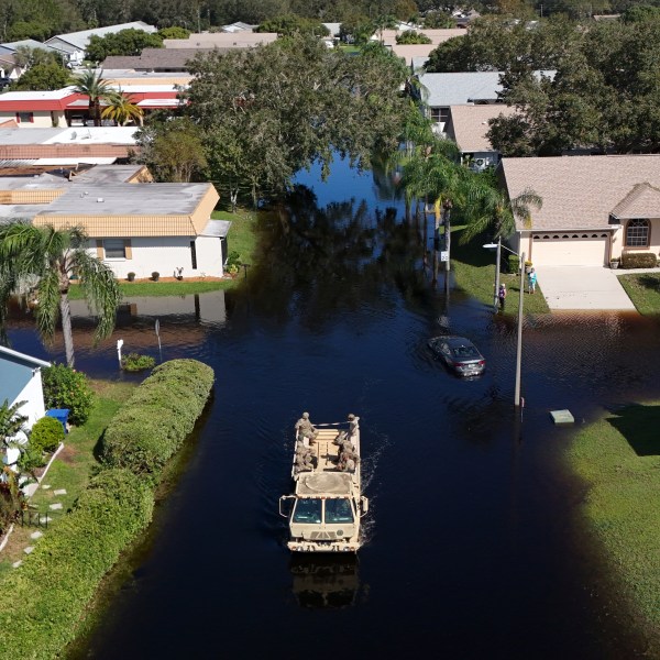 A truck from the Florida National Guard goes out to help residents trapped in their homes as waters rise after Hurricane Milton caused the Anclote River to flood, Friday, Oct. 12, 2024, in New Port Richey, Fla. (AP Photo/Mike Carlson)