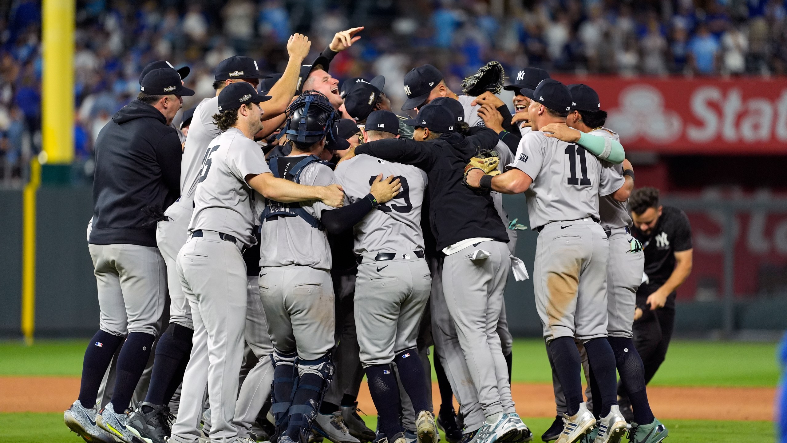 Members of the New York Yankees celebrate after defeating the Kansas City Royals 3-1 in Game 4 of an American League Division baseball playoff series and move on to the ALCS Thursday, Oct. 10, 2024, in Kansas City, Mo. (AP Photo/Charlie Riedel)