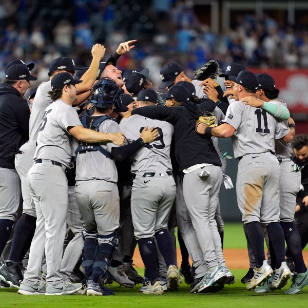 Members of the New York Yankees celebrate after defeating the Kansas City Royals 3-1 in Game 4 of an American League Division baseball playoff series and move on to the ALCS Thursday, Oct. 10, 2024, in Kansas City, Mo. (AP Photo/Charlie Riedel)