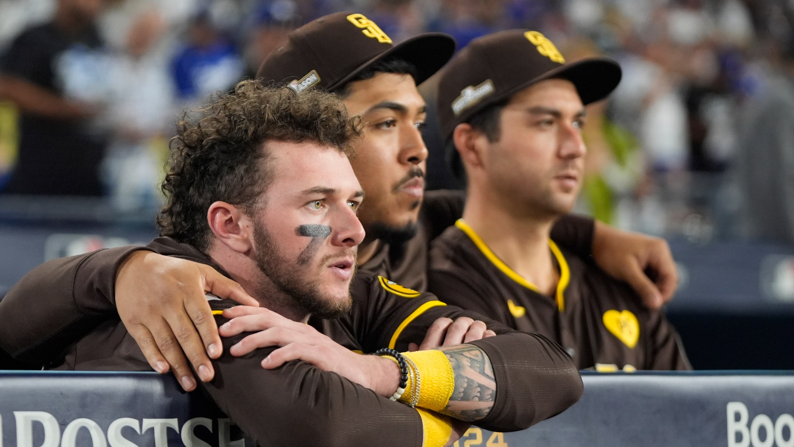 San Diego Padres center fielder Jackson Merrill, left, looks on alongside relief pitcher Jeremiah Estrada, center, and catcher Kyle Higashioka after a loss to the Los Angeles Dodgers in Game 5 of a baseball NL Division Series Friday, Oct. 11, 2024, in Los Angeles. (AP Photo/Mark J. Terrill)