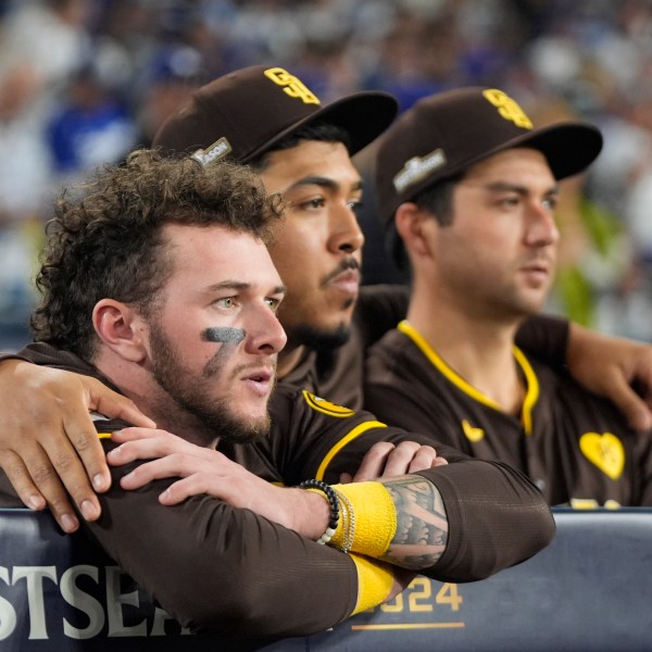 San Diego Padres center fielder Jackson Merrill, left, looks on alongside relief pitcher Jeremiah Estrada, center, and catcher Kyle Higashioka after a loss to the Los Angeles Dodgers in Game 5 of a baseball NL Division Series Friday, Oct. 11, 2024, in Los Angeles. (AP Photo/Mark J. Terrill)