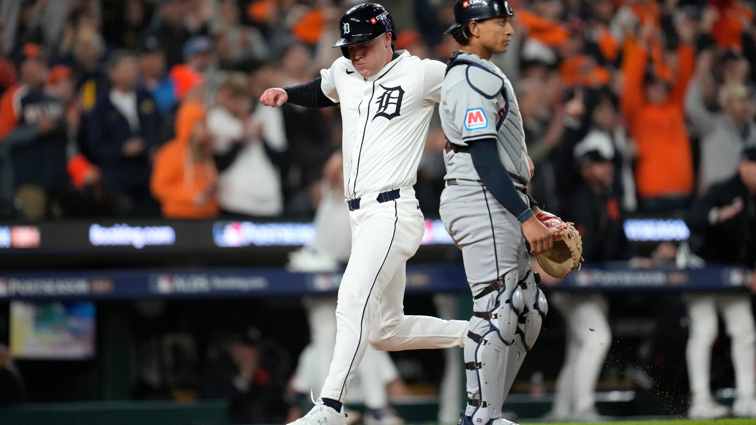 Detroit Tigers' Kerry Carpenter, left, scores in front of Cleveland Guardians catcher Bo Naylor in the sixth inning during Game 4 of a baseball American League Division Series, Thursday, Oct. 10, 2024, in Detroit. (AP Photo/Paul Sancya)