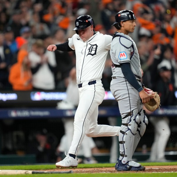 Detroit Tigers' Kerry Carpenter, left, scores in front of Cleveland Guardians catcher Bo Naylor in the sixth inning during Game 4 of a baseball American League Division Series, Thursday, Oct. 10, 2024, in Detroit. (AP Photo/Paul Sancya)