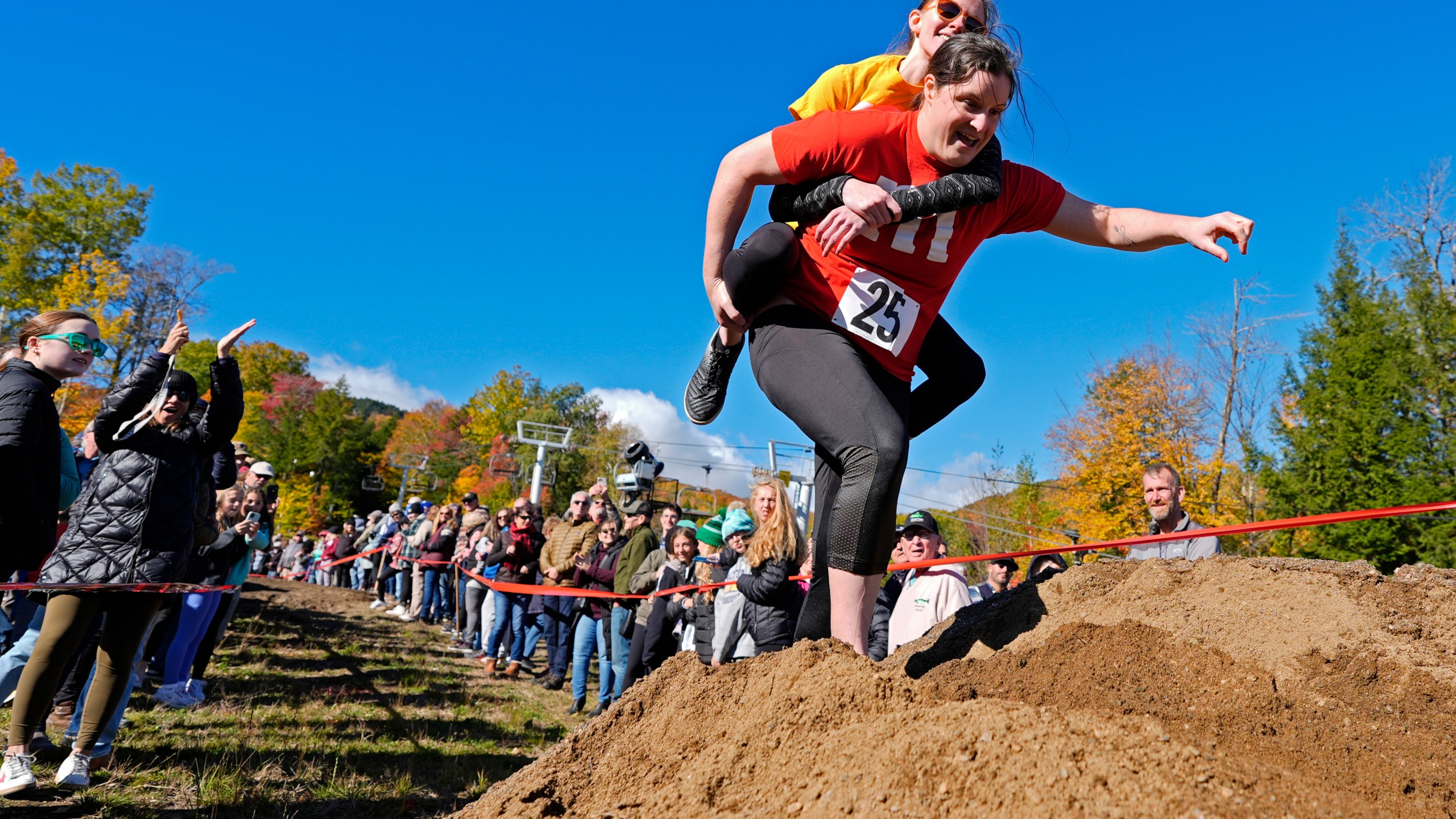 Molly Sunburn carries Megan Crowley over a sand pile during the North American Wife Carrying Championship, Saturday, Oct. 12, 2024, at Sunday River ski resort in Newry, Maine. (AP Photo/Robert F. Bukaty)