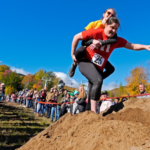 Molly Sunburn carries Megan Crowley over a sand pile during the North American Wife Carrying Championship, Saturday, Oct. 12, 2024, at Sunday River ski resort in Newry, Maine. (AP Photo/Robert F. Bukaty)