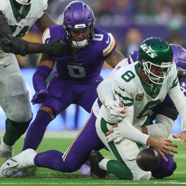 New York Jets quarterback Aaron Rodgers (8), right, is sacked by Minnesota Vikings' Harrison Phillips during the second half of an NFL football game, Sunday, Oct. 6, 2024, at the Tottenham Hotspur stadium in London. (AP Photo/Ian Walton)