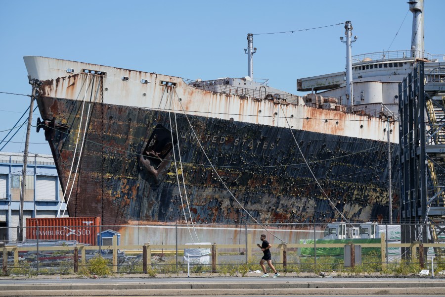 FILE - A person runs past the S.S. United States moored on the Delaware River in Philadelphia, Sept. 4, 2024. (AP Photo/Matt Rourke, File)