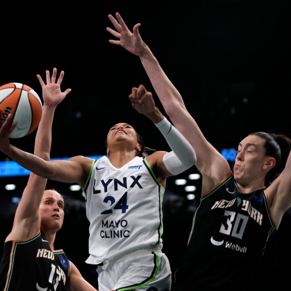 Minnesota Lynx's Napheesa Collier, center, attempts to score against New York Liberty's Leonie Fiebich, left, and Breanna Stewart, right during the second half in Game 1 of a WNBA basketball final playoff series, Thursday, Oct. 10, 2024, in New York. (AP Photo/Pamela Smith)