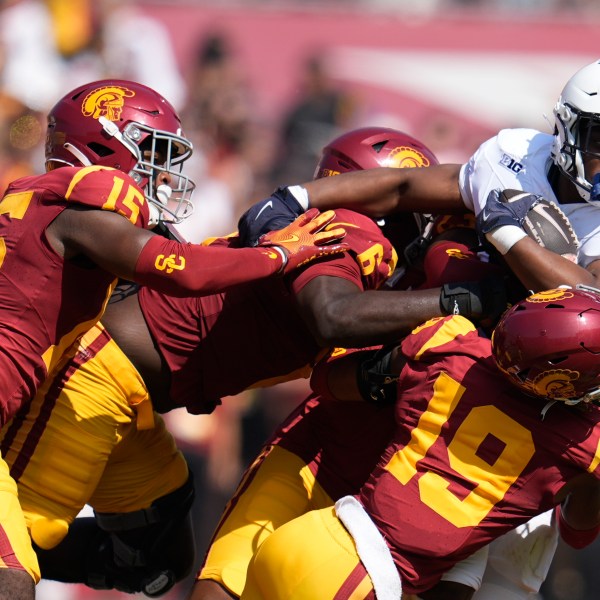 Penn State running back Kaytron Allen (13) is tackled by Southern California cornerback John Humphrey (19), defensive end Anthony Lucas (6) and safety Anthony Beavers Jr. (15) during the first half of an NCAA college football game Saturday, Oct. 12, 2024, in Los Angeles. (AP Photo/Marcio Jose Sanchez)