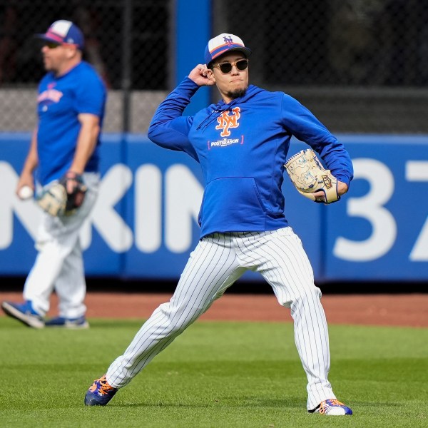 New York Mets pitcher Kodai Senga shags balls in the outfield before Game 3 of the National League baseball playoff series against the Philadelphia Phillies, Tuesday, Oct. 8, 2024, in New York. (AP Photo/Frank Franklin II)