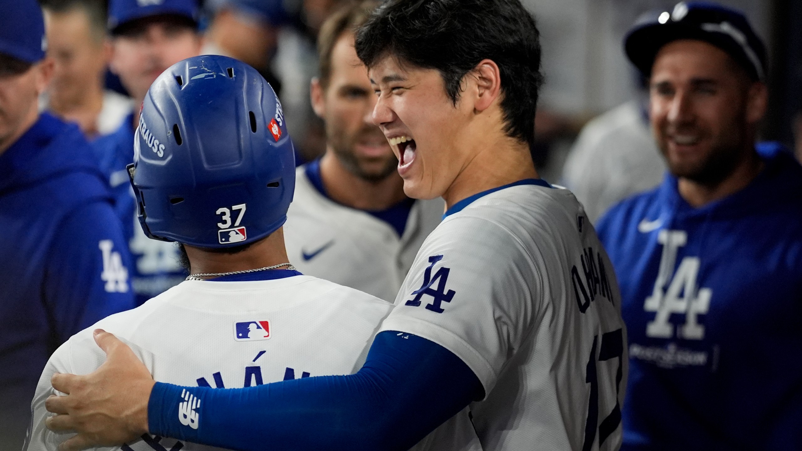 Los Angeles Dodgers' Teoscar Hernández, left, celebrates his solo home run in the dugout with Shohei Ohtani during the seventh inning in Game 5 of a baseball NL Division Series against the San Diego Padres, Friday, Oct. 11, 2024, in Los Angeles. (AP Photo/Ashley Landis)