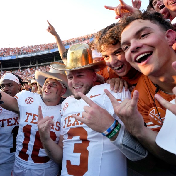 Texas quarterback Quinn Ewers (3) celebrates with teammates and fans after the teams win against Oklahoma in an NCAA college football game in Dallas, Saturday, Oct. 12, 2024. (AP Photo/Jeffrey McWhorter)