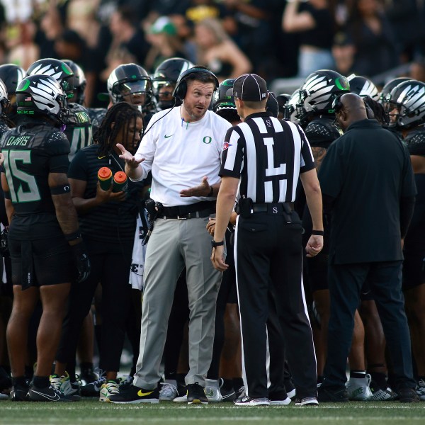 Oregon head coach Dan Lanning, center left, talks with a referee, center right, during an NCAA college football game against Ohio State, Saturday, Oct. 12, 2024, in Eugene, Ore. (AP Photo/Lydia Ely)