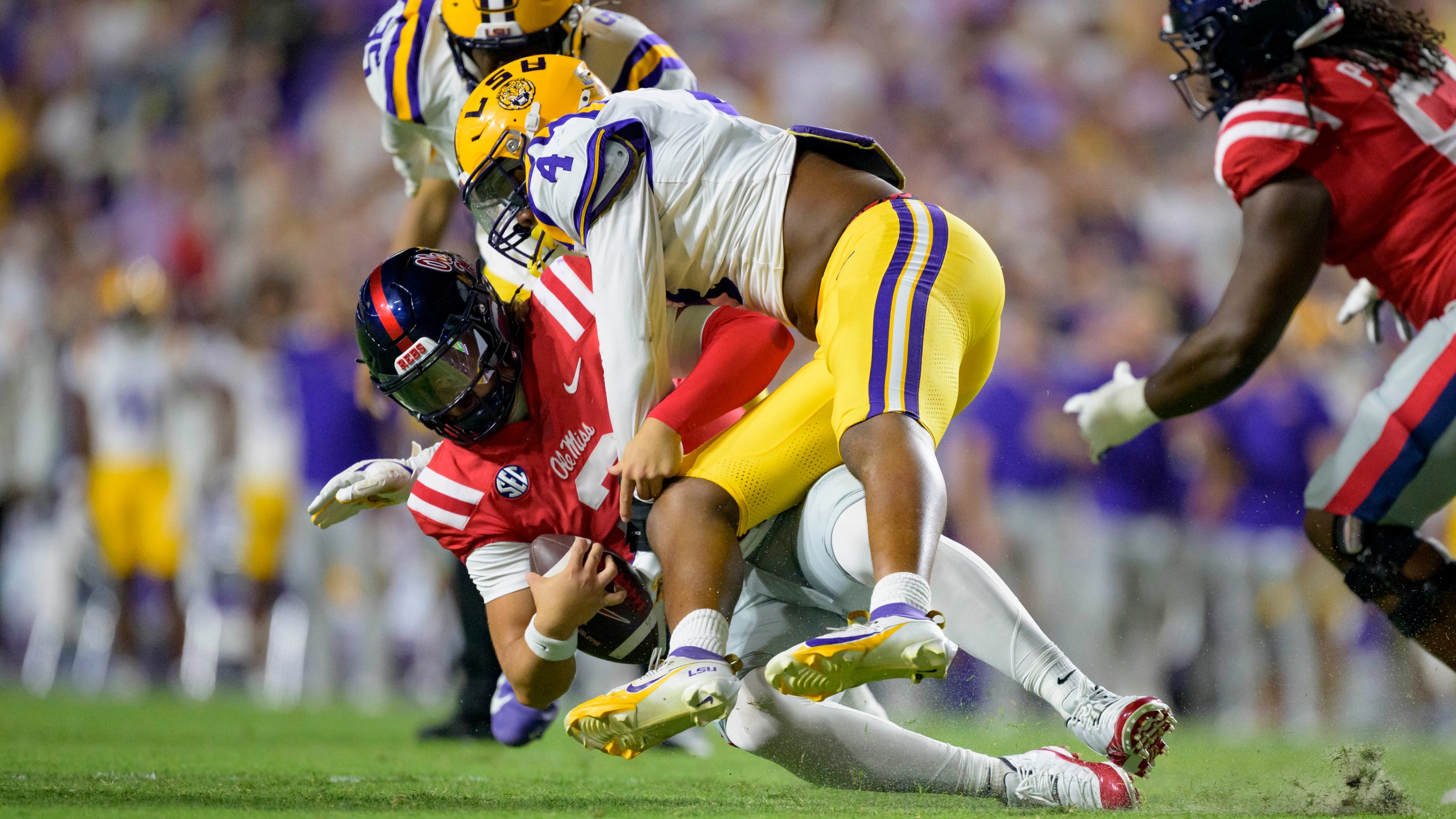 Mississippi quarterback Jaxson Dart (2) is sacked by LSU defensive end Bradyn Swinson (4) during the first half of an NCAA college football game in Baton Rouge, La., Saturday, Oct. 12, 2024. (AP Photo/Matthew Hinton)