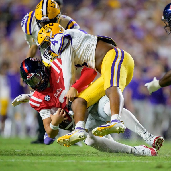 Mississippi quarterback Jaxson Dart (2) is sacked by LSU defensive end Bradyn Swinson (4) during the first half of an NCAA college football game in Baton Rouge, La., Saturday, Oct. 12, 2024. (AP Photo/Matthew Hinton)