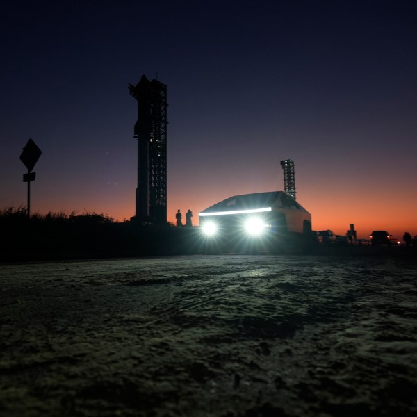 A Tesla Cybertruck passes as the sun sets behind SpaceX's mega rocket Starship, Saturday, Oct. 12, 2024, in Boca Chica, Texas. (AP Photo/Eric Gay)