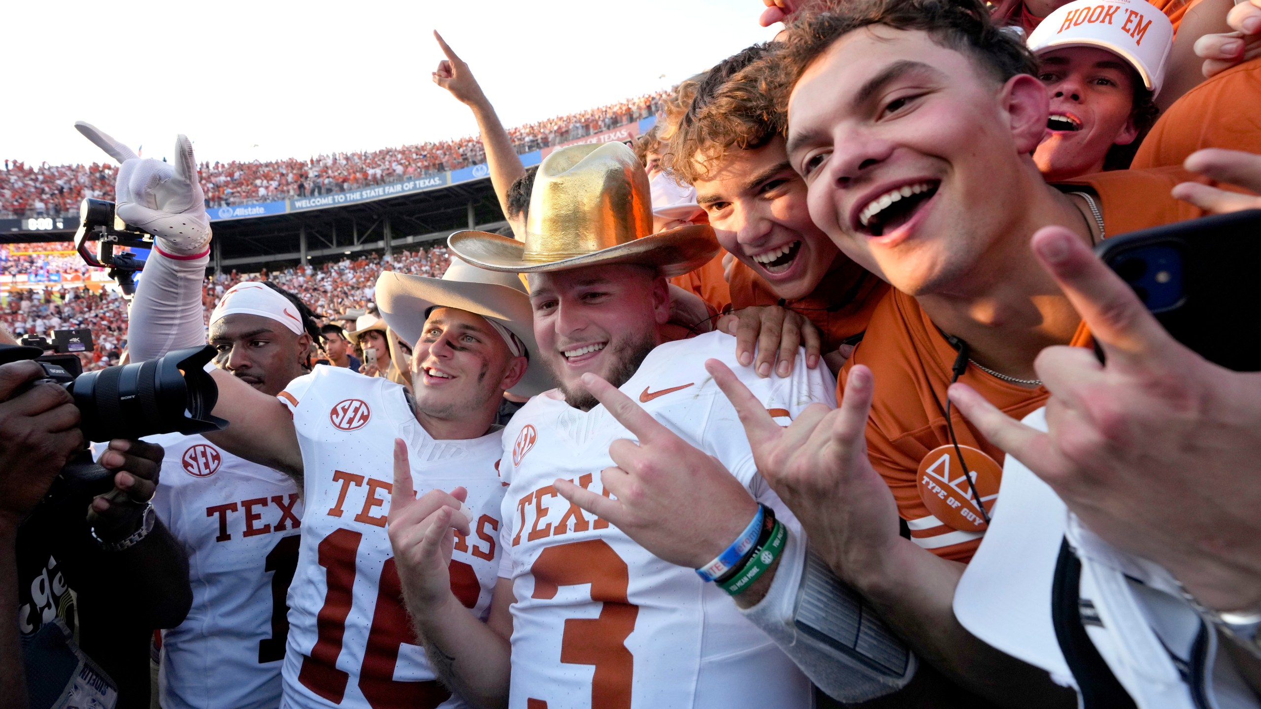 Texas quarterback Quinn Ewers (3) celebrates with teammates and fans after the teams win against Oklahoma in an NCAA college football game in Dallas, Saturday, Oct. 12, 2024. (AP Photo/Jeffrey McWhorter)