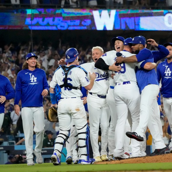 The Los Angeles Dodgers celebrate off the mound after defeating the San Diego Padres in Game 5 of a baseball NL Division Series Friday, Oct. 11, 2024, in Los Angeles. (AP Photo/Mark J. Terrill)