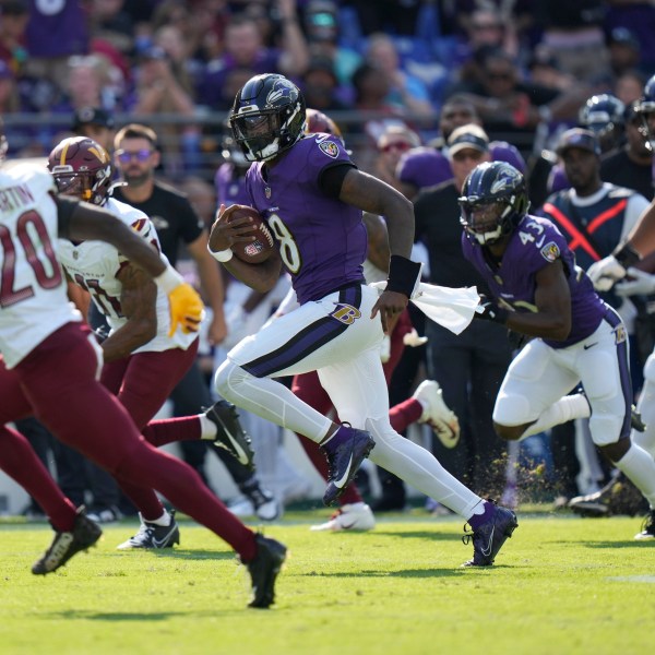 Baltimore Ravens quarterback Lamar Jackson (8) runs for a 33-yard gain as Washington Commanders safety Quan Martin (20) defends during the second half of an NFL football game Sunday, Oct. 13, 2024, in Baltimore. (AP Photo/Stephanie Scarbrough)