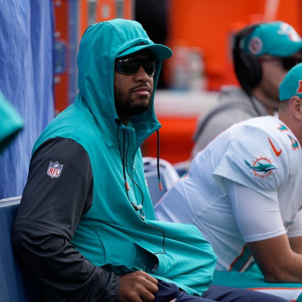 Miami Dolphins quarterback Tua Tagovailoa, center, looks on from the sideline during the first half of an NFL football game against the Seattle Seahawks, Sunday, Sept. 22, 2024, in Seattle. (AP Photo/Stephen Brashear)