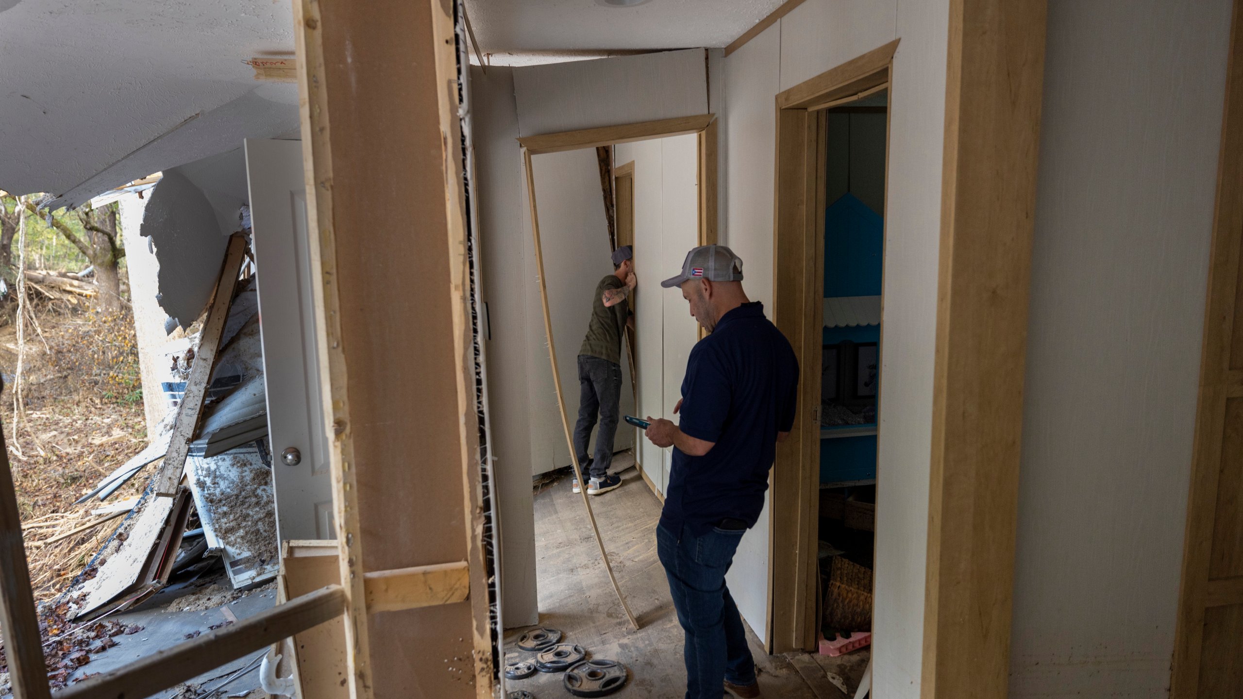 FEMA employee Jirau Alvaro works with Daniel Mancini, doing a report on the damage to his property on Sunday, October 6, 2024 in rural Buncombe County, near Black Mountain, N.C. (Robert Willett/The News & Observer via AP)