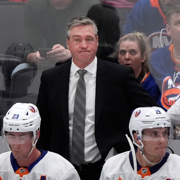 New York Islanders head coach Patrick Roy, center, looks on from behind centers Brock Nelson (29) and Bo Horvat (14) during the second period of an NHL hockey game against the Dallas Stars Saturday, Oct. 12, 2024, in Dallas. (AP Photo/LM Otero)