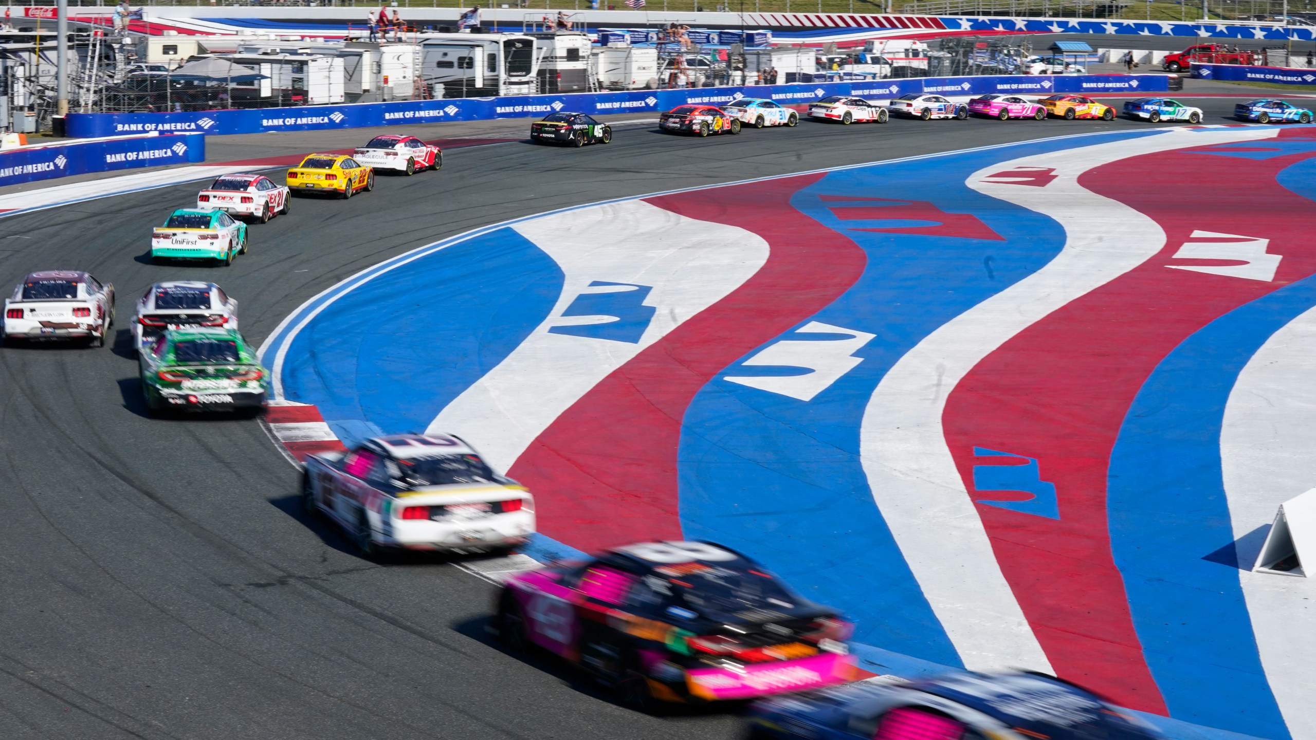 Drivers take their cars through Turn 3 during a NASCAR Cup Series auto race at Charlotte Motor Speedway in Concord, N.C., Sunday, Oct. 13, 2024. (AP Photo/Chuck Burton)