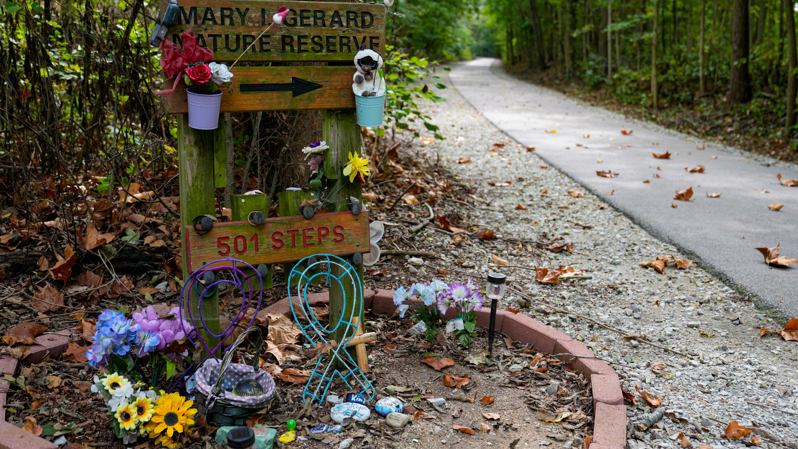 Decorated stones bearing the names of Abigail Williams and Liberty German, who were killed in February 2017, are placed at a memorial along the Monon High Bridge Trail in Delphi, Ind., Tuesday, Oct. 1, 2024. (AP Photo/Michael Conroy)