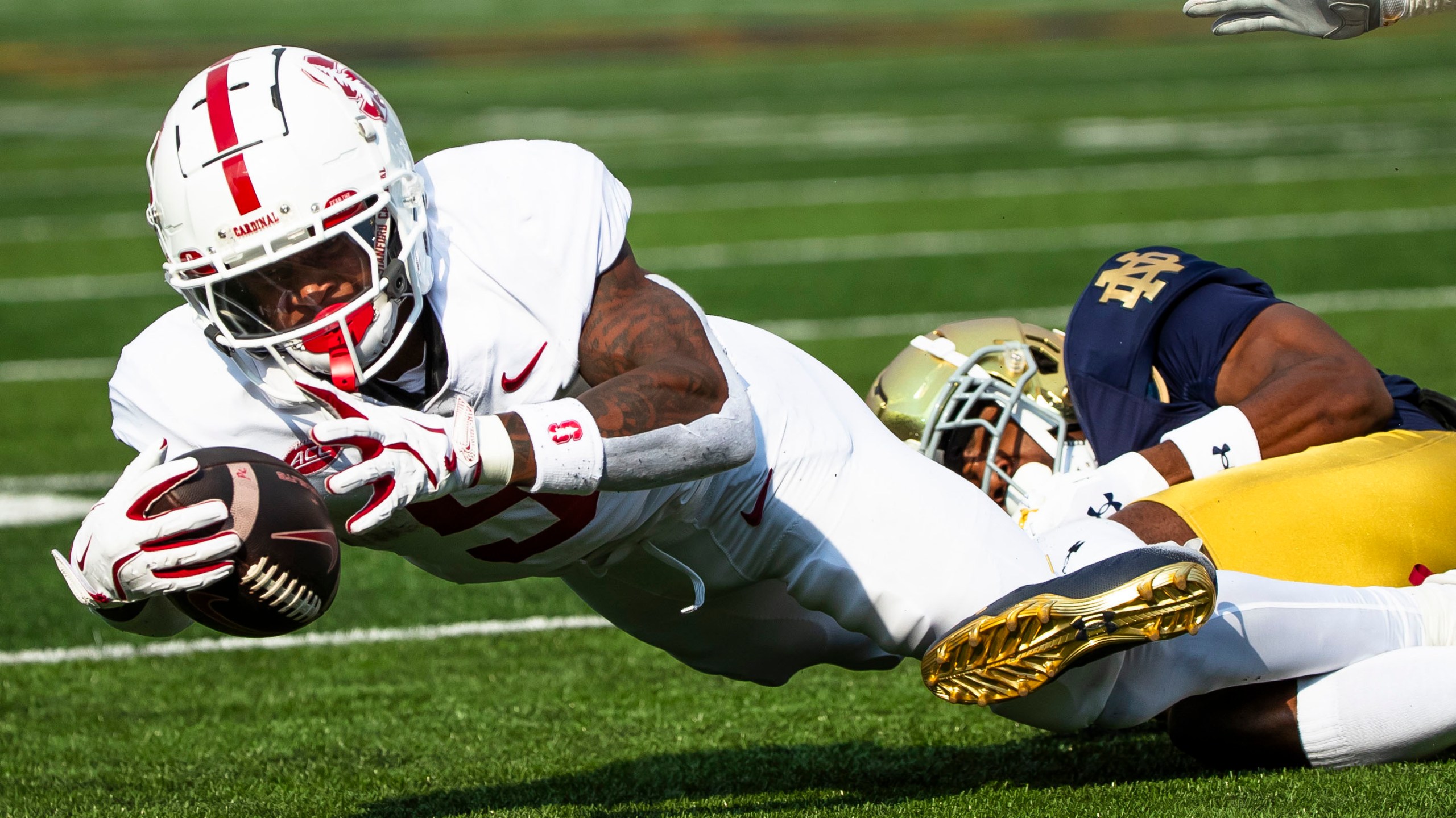 Stanford running back Chris Davis Jr., left, reaches for extra yards as Notre Dame defensive back Benjamin Morrison, right, tackles him during an NCAA college football game Saturday, Oct. 12, 2024, in South Bend, Ind. (AP Photo/Michael Caterina)