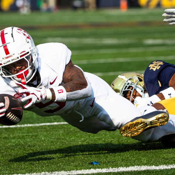 Stanford running back Chris Davis Jr., left, reaches for extra yards as Notre Dame defensive back Benjamin Morrison, right, tackles him during an NCAA college football game Saturday, Oct. 12, 2024, in South Bend, Ind. (AP Photo/Michael Caterina)