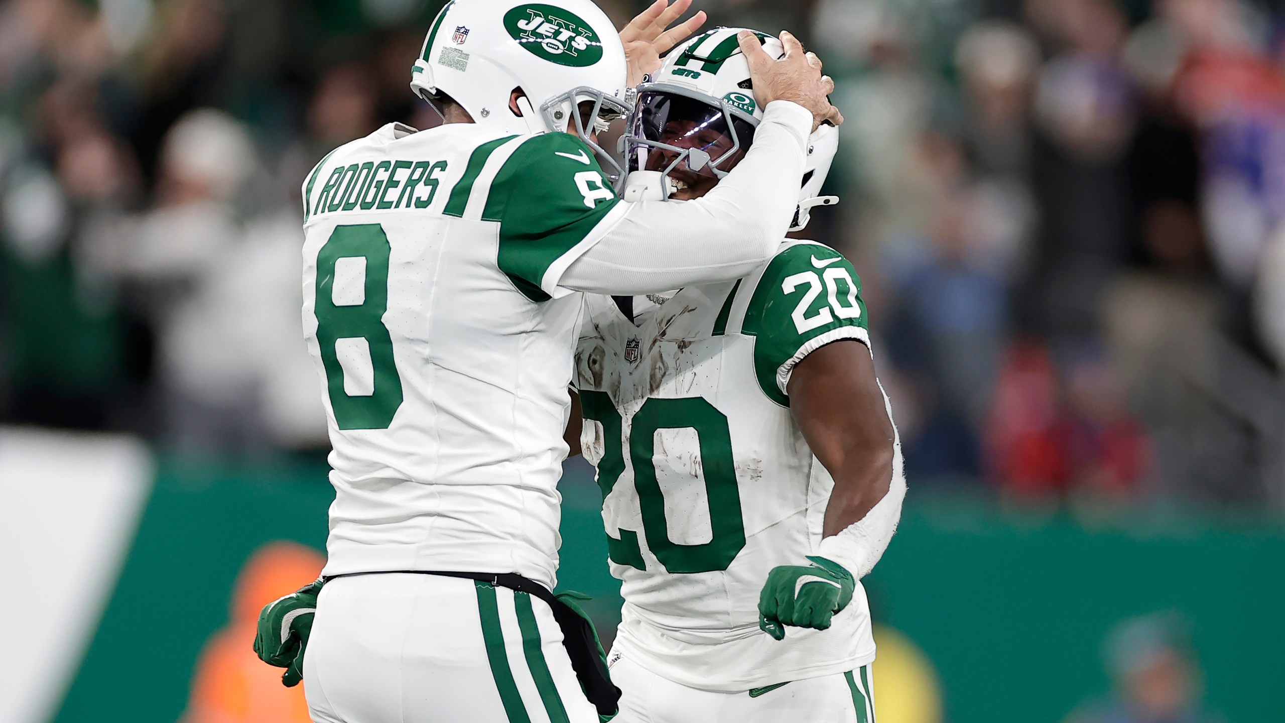 New York Jets quarterback Aaron Rodgers (8) celebrates with running back Frank Gore Jr. (20) after throwing a touchdown pass to wide receiver Allen Lazard during the first half of an NFL football game against the Buffalo Bills in East Rutherford, N.J., Monday, Oct. 14, 2024. (AP Photo/Adam Hunger)