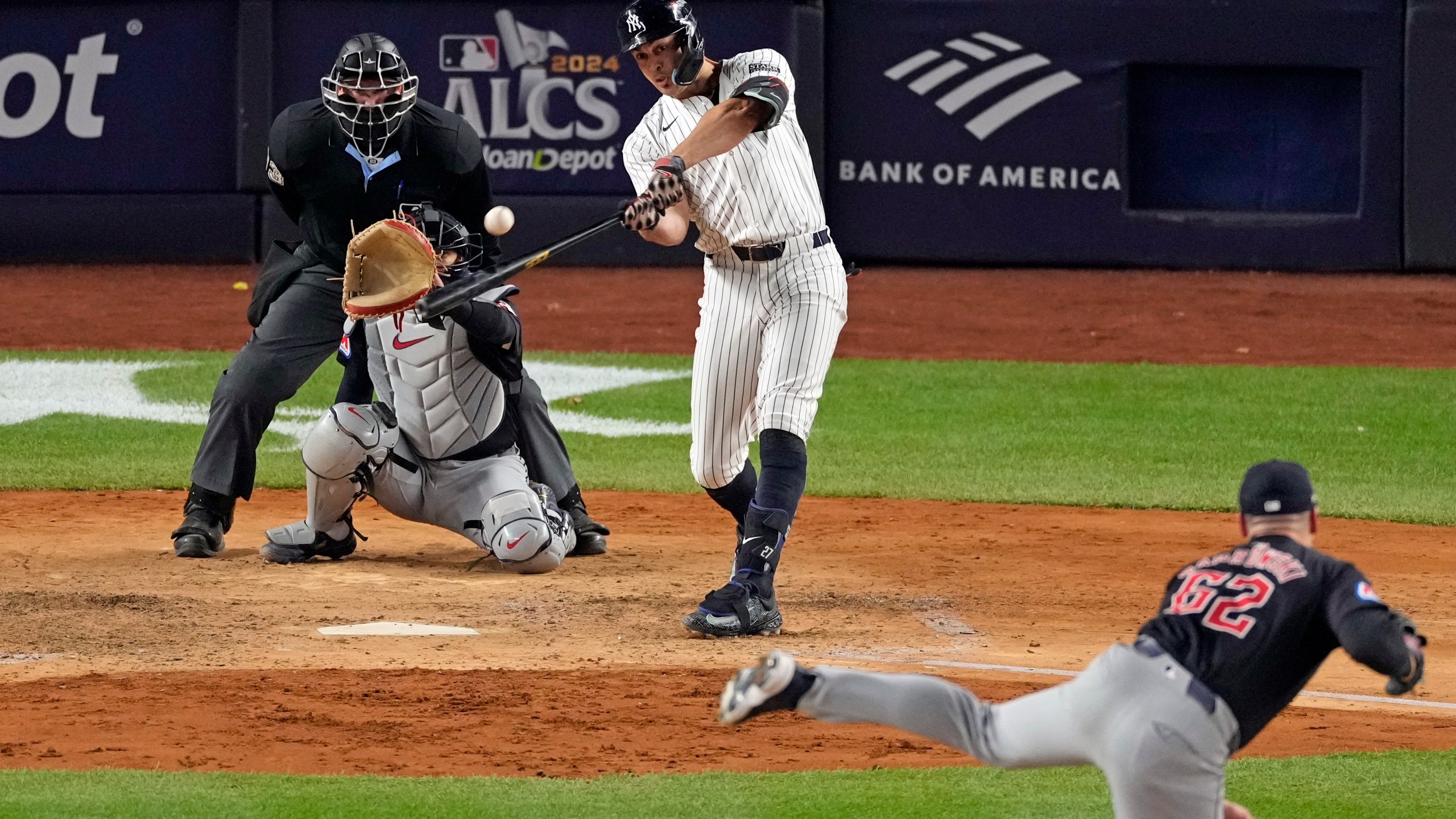 New York Yankees' Giancarlo Stanton, center, hits a home run off Cleveland Guardians relief pitcher Erik Sabrowski (62) during the seventh inning in Game 1 of the baseball AL Championship Series Monday, Oct. 14, 2024, in New York. (AP Photo/Seth Wenig)