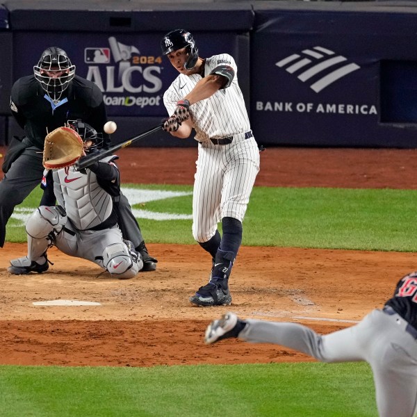 New York Yankees' Giancarlo Stanton, center, hits a home run off Cleveland Guardians relief pitcher Erik Sabrowski (62) during the seventh inning in Game 1 of the baseball AL Championship Series Monday, Oct. 14, 2024, in New York. (AP Photo/Seth Wenig)