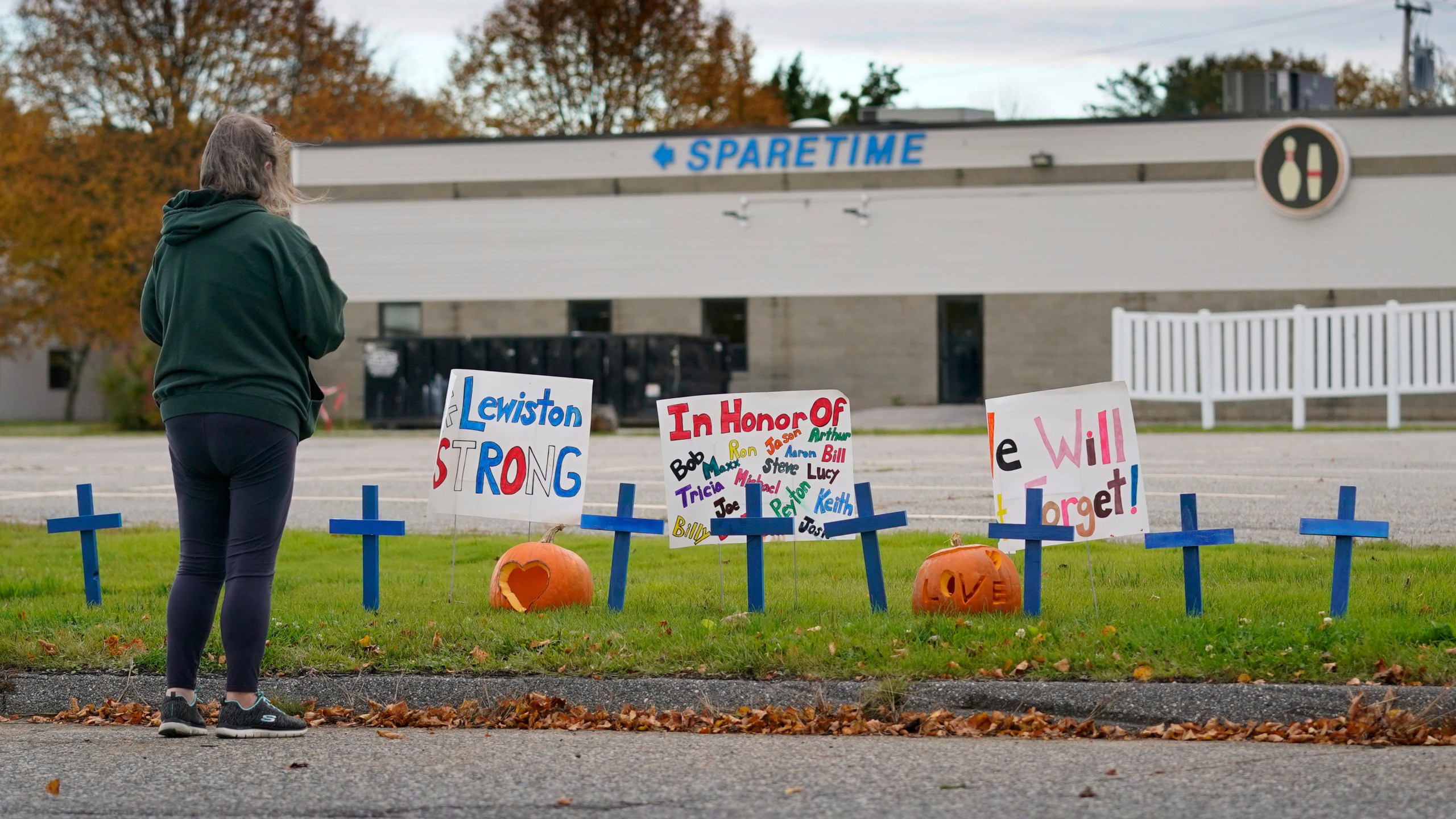 FILE - A woman visits a makeshift memorial outside Sparetime Bowling Alley, the site of a mass shooting, Oct. 28, 2023, in Lewiston, Maine. (AP Photo/Robert F. Bukaty, File)