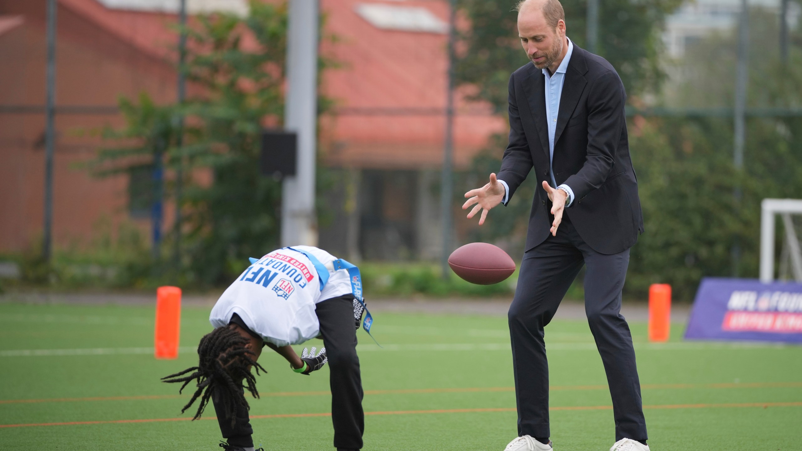 Britain's Prince William catches the football as he attends a NFL Foundation NFL Flag event, an inclusive and fast paced American Football format, in London, Tuesday, Oct. 15, 2024. (AP Photo/Kin Cheung, Pool)