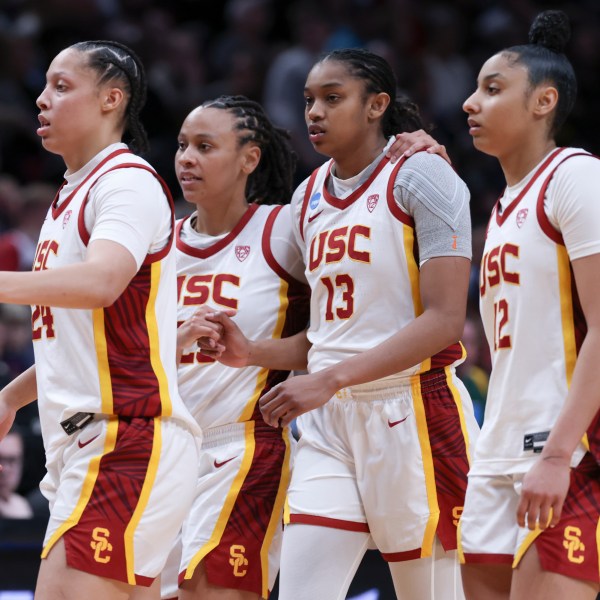 FILE - Southern California players Kaitlyn Davis, left, McKenzie Forbes, second from left, Rayah Marshall (13) and JuJu Watkins react after a Sweet 16 college basketball game against Baylor in the women's NCAA Tournament, March 30, 2024, in Portland, Ore. (AP Photo/Howard Lao, File)