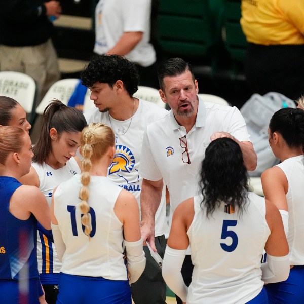 San Jose State head coach Todd Kress, center back, talks to his players during a timeout during the first set of an NCAA college volleyball match against Colorado State, Thursday, Oct. 3, 2024, in Fort Collins, Colo. (AP Photo/David Zalubowski)