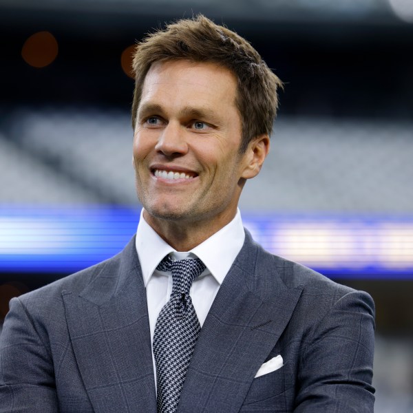 Fox Sports lead NFL analyst Tom Brady stands on the field during warmups before an NFL football game between the Detroit Lions and the Dallas Cowboys in Arlington, Texas, Sunday, Oct. 13, 2024. (AP Photo/Gareth Patterson)