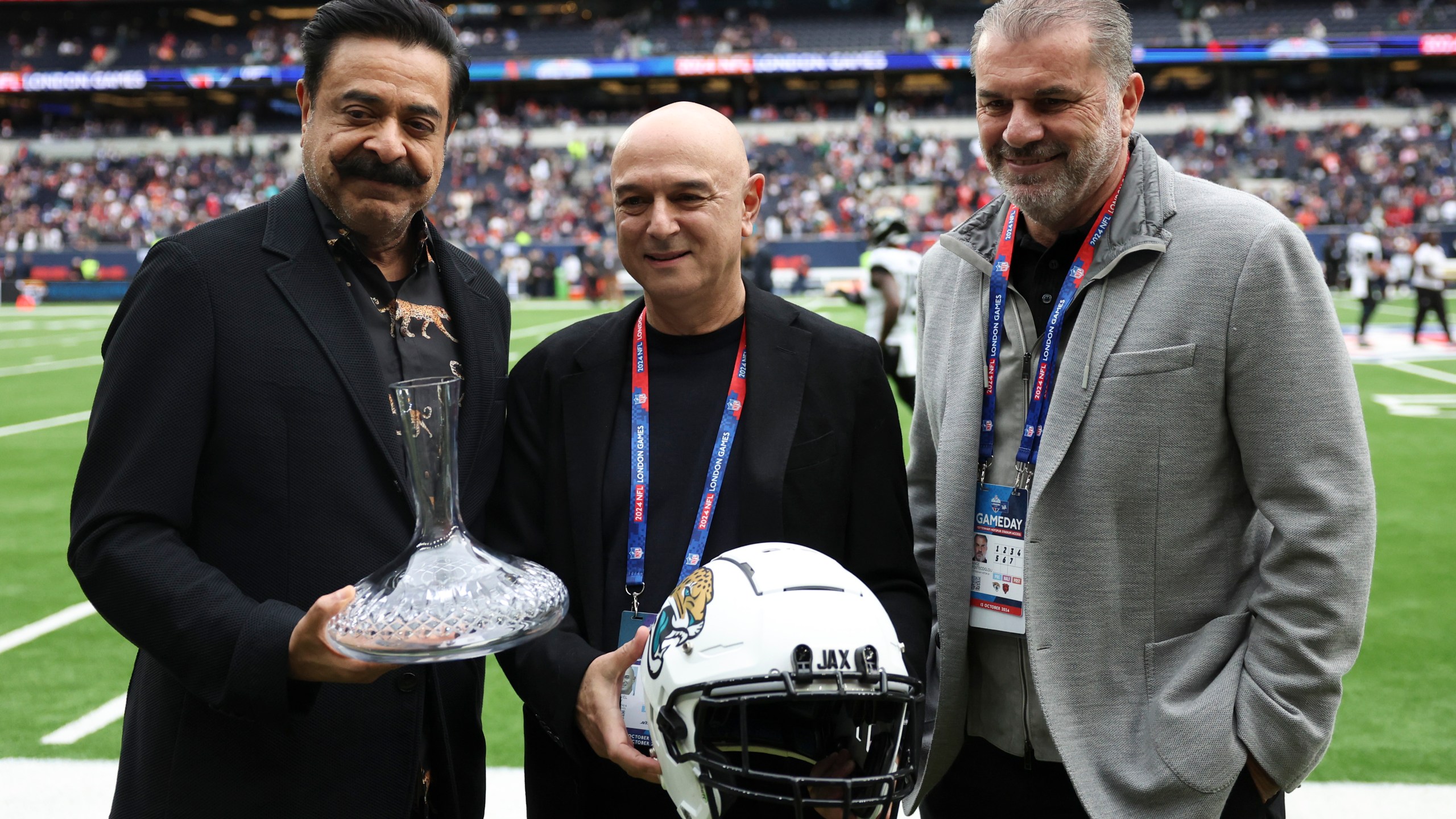 Jaguars owner Shahid Khan, Tottenham chairman Daniel Levy and Spurs head coach Ange Postecoglou, from left, pose for a photo before an NFL football game at the Tottenham Hotspur stadium between the Jacksonville Jaguars and Chicago Bears in London, Sunday, Oct. 13, 2024. (AP Photo/Ian Walton)