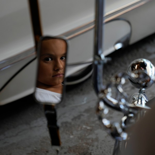 Daniel Marquez, 8, is reflected in the mirror of his chrome lowrider bike, built by himself and family friends in memory of his late father Alberto, a longtime member of lowrider car clubs, Saturday, Sept. 14, 2024, at his home in Frankfort, Ill. (AP Photo/Erin Hooley)