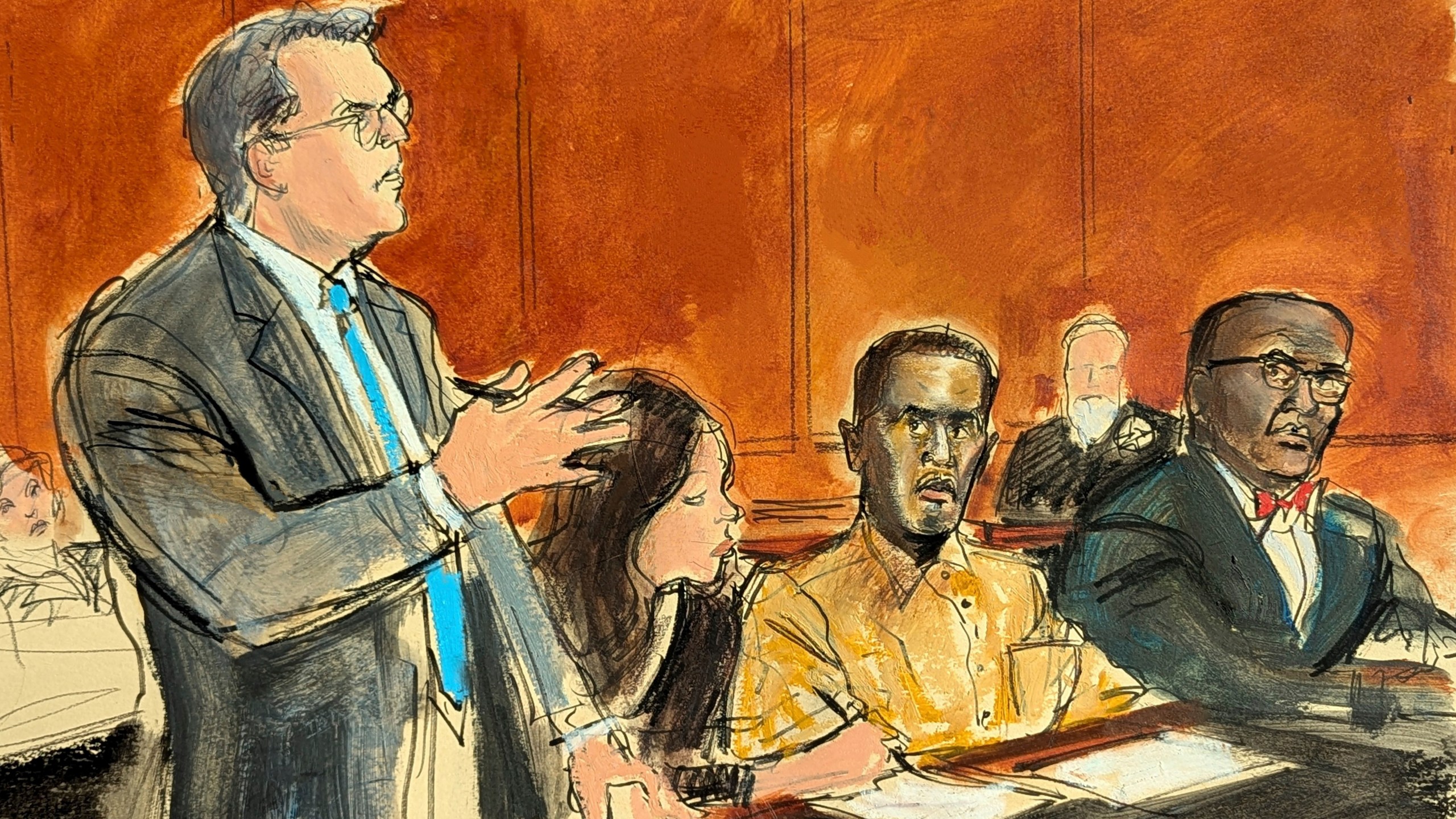 In this courtroom sketch, Sean "Diddy" Combs' defense attorney Marc Agnifilo, left, addresses the judge while Combs, seated second from right, in prison uniform, watches during a hearing in federal court in New York, Thursday, Oct. 10, 2024. Combs' new defense attorney, Anthony Ricco is seated far right. (Elizabeth Williams via AP)