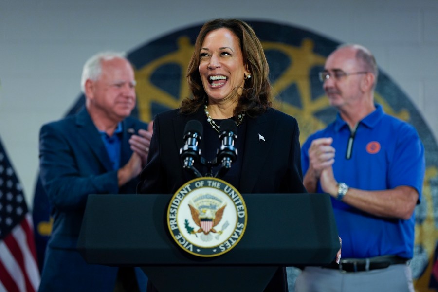 FILE - Democratic presidential nominee Vice President Kamala Harris, with Democratic vice presidential nominee Minnesota Gov. Tim Walz, left, and UAW President Shawn Fain, speaks at a campaign rally at UAW Local 900, Aug. 8, 2024, in Wayne, Mich. (AP Photo/Julia Nikhinson, File)