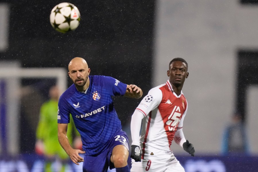 Dinamo's goalkeeper Ivan Filipovic, left, and Monaco's Folarin Balogun go for the ball during the Champions League soccer match between Dinamo Zagreb and Monaco at Maksimir stadium in Zagreb, Croatia, Wednesday, Oct. 2, 2024. (AP Photo/Darko Bandic)