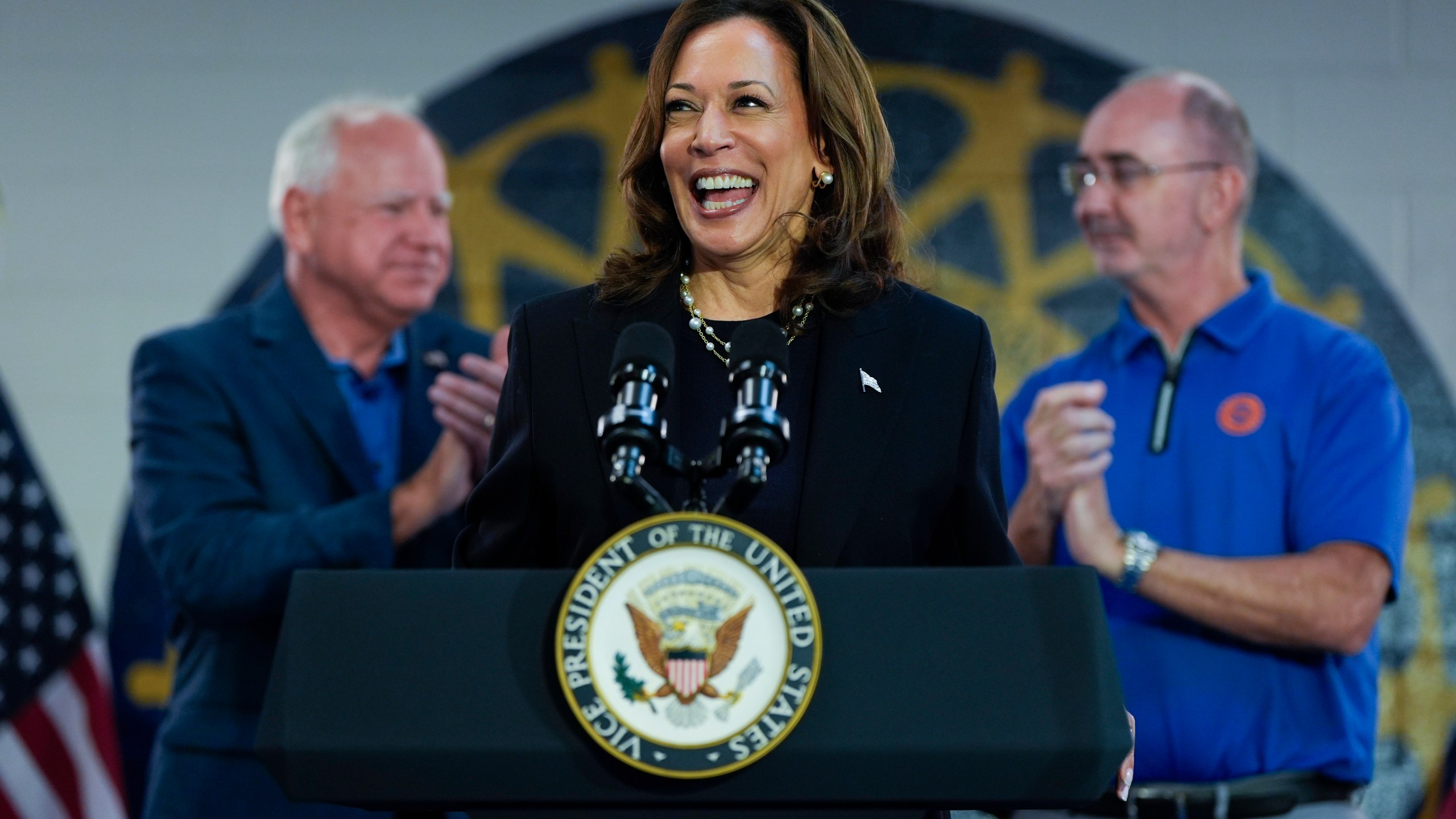 FILE - Democratic presidential nominee Vice President Kamala Harris, with Democratic vice presidential nominee Minnesota Gov. Tim Walz, left, and UAW President Shawn Fain, speaks at a campaign rally at UAW Local 900, Aug. 8, 2024, in Wayne, Mich. (AP Photo/Julia Nikhinson, File)