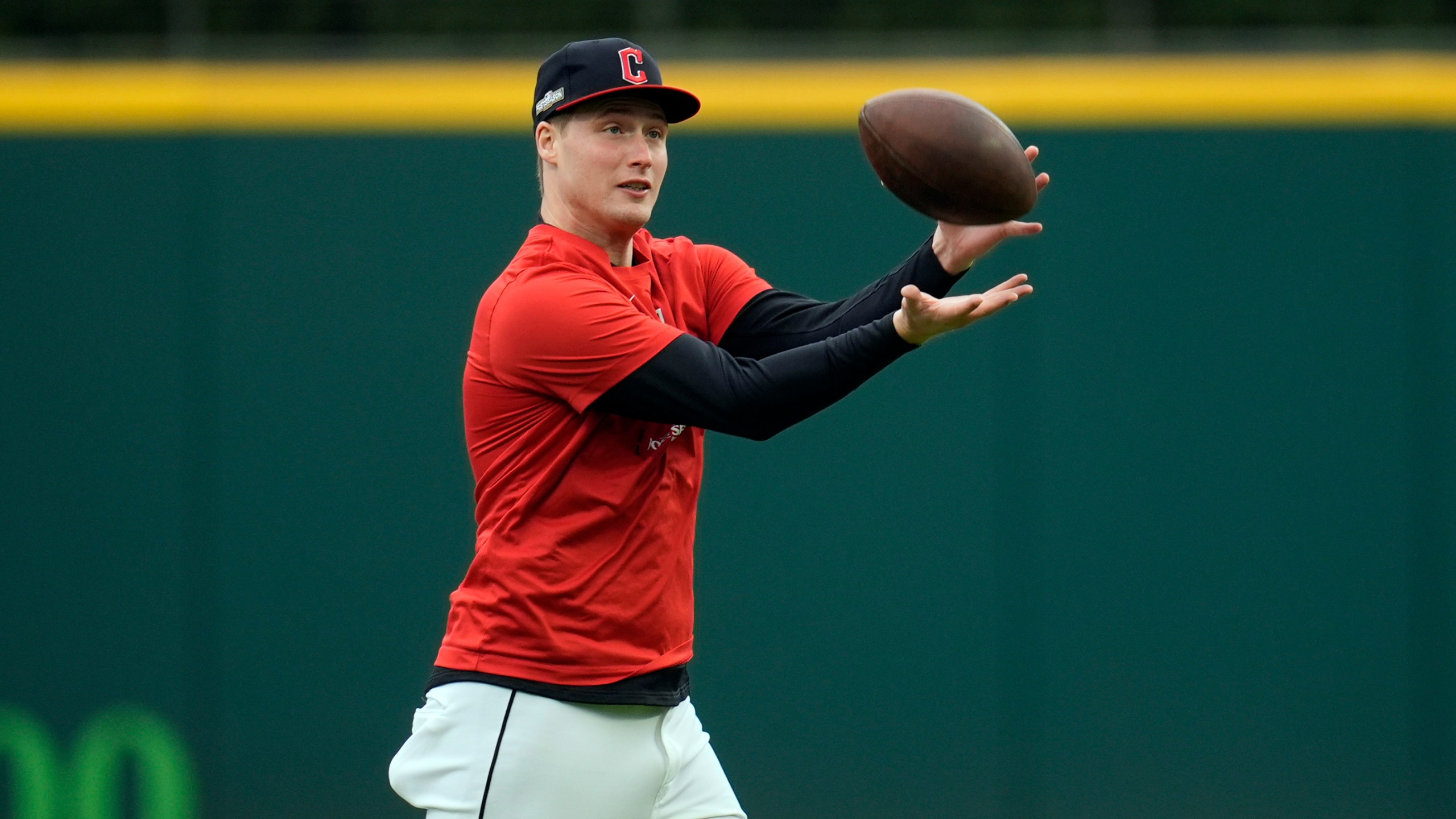 Cleveland Guardians pitcher Tim Herrin catches a football during a workout Wednesday, Oct. 16, 2024, in Cleveland, ahead of Game 3 of the baseball AL Championship Series. (AP Photo/Sue Ogrocki)